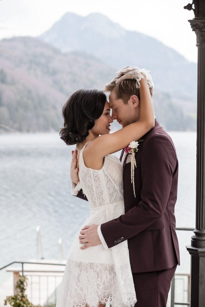 Brautpaar liegt sich am Ufer des Fuschlsees in den Armen - Hochzeitsplanung in Österreich - Glanz Hochzeiten